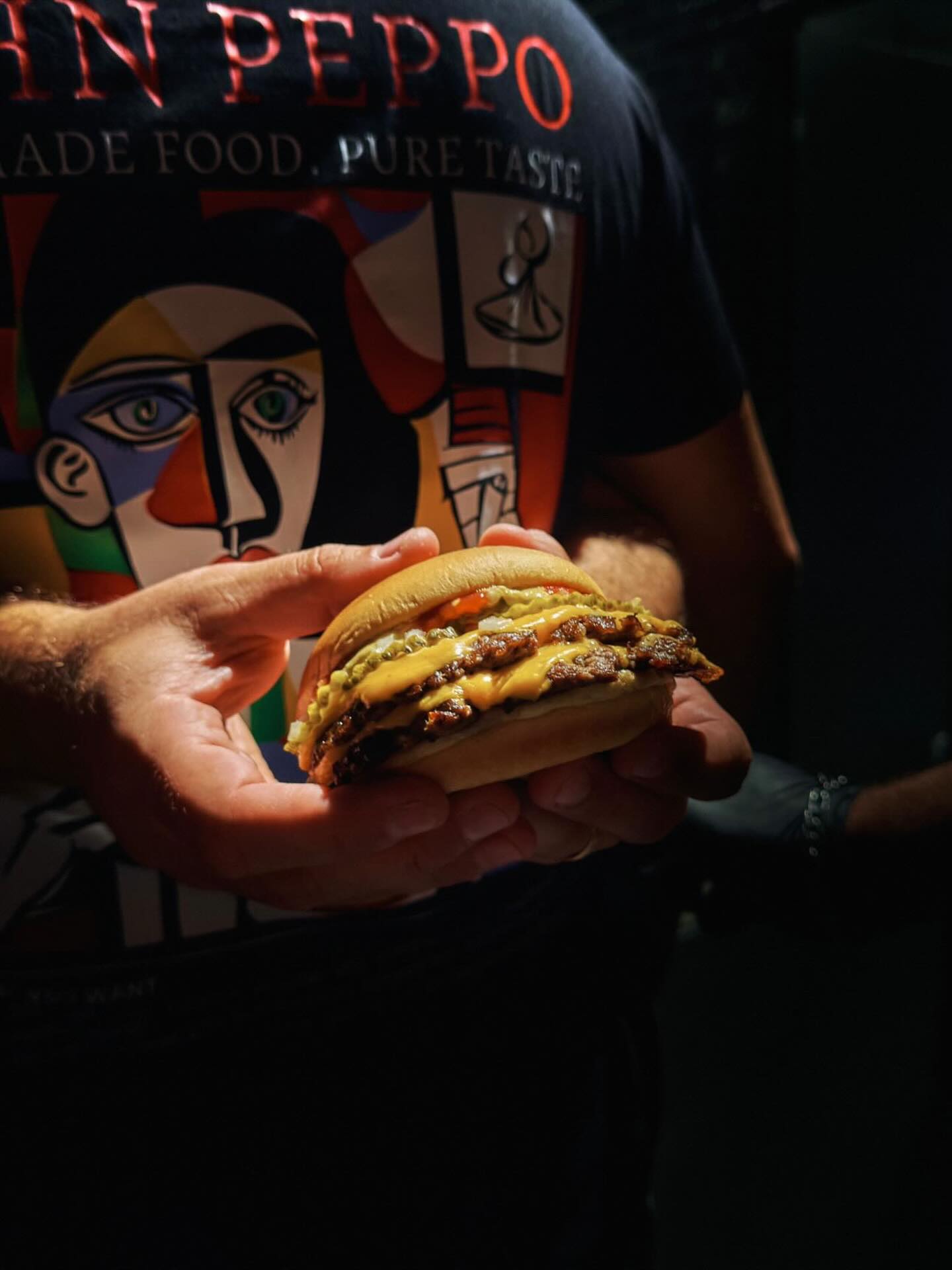 John Peppo Burger in der Hand